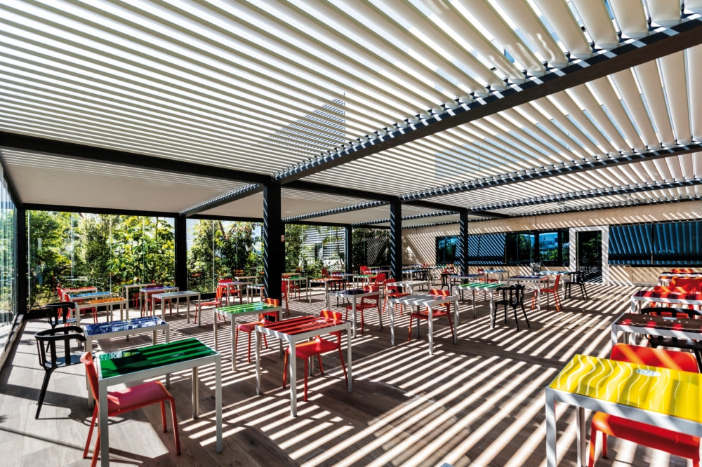 Glazen wanden onder een pergola op een horecaterras