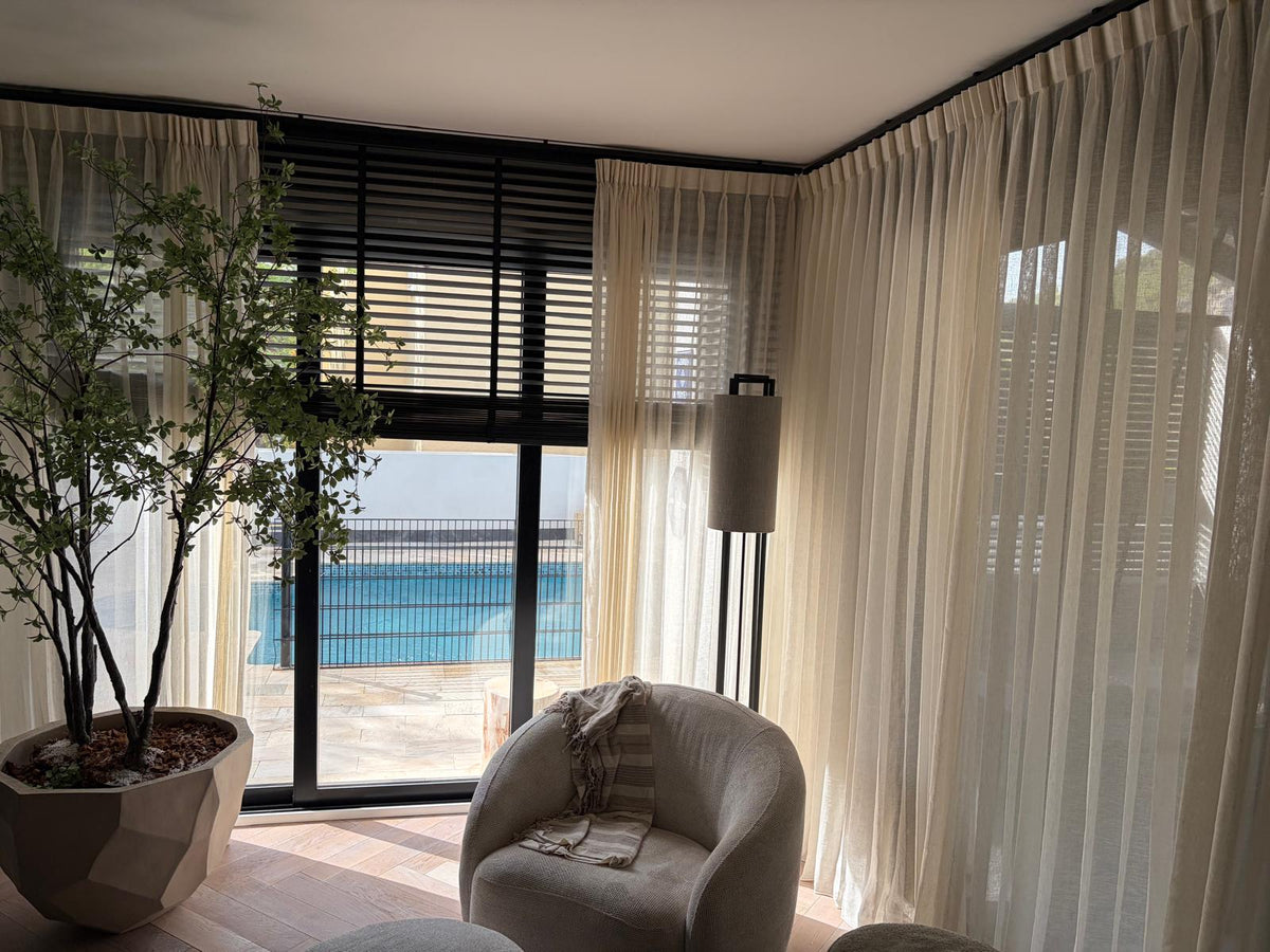 Lichte gordijnen en zwarte jaloezieën in een sfeervol interieur – Port of Altea
